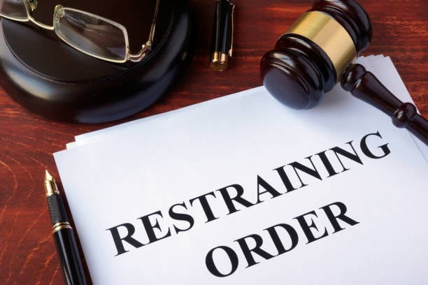 What is the difference between a non-molestation order (injunction) and a restraining order?